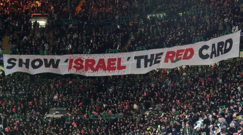 Suporter memegang spanduk bertuliskan 'Show Israel the Red Card' sebagai bentuk protes, mendukung isu UEFA banned Israel.